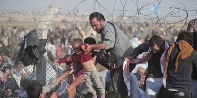 Imagini cutremuratoare cu mii de refugiati sirieni care incearca sa intre in Turcia. Un gard rupt le-a servit ca punct de trecere